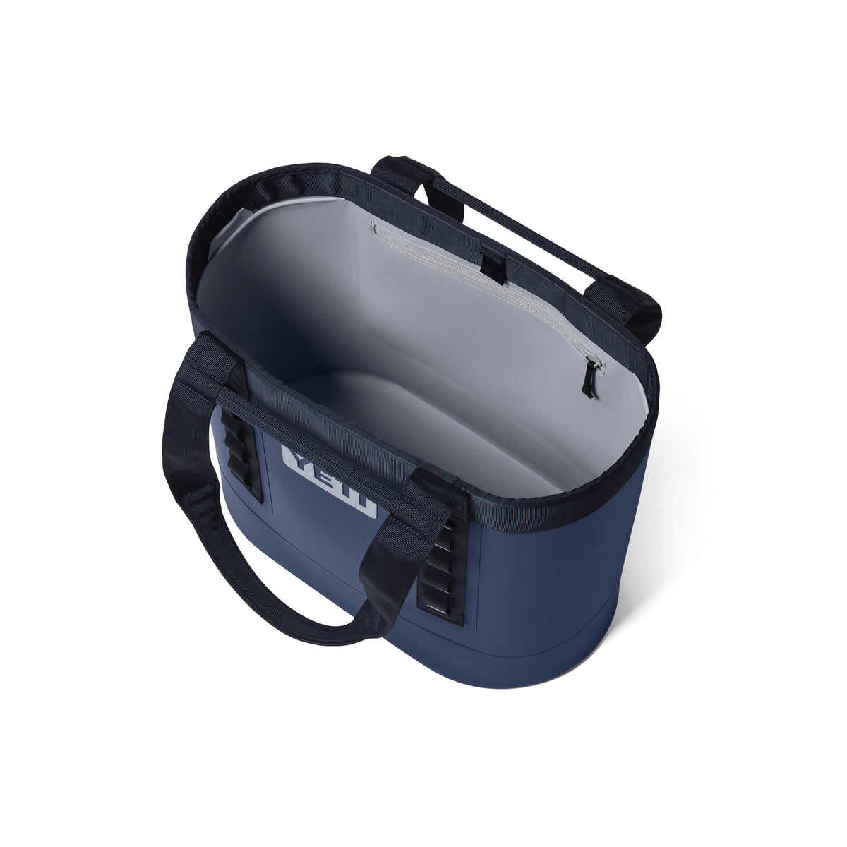 Draufsicht auf eine geöffnete YETI® Tragetasche Camino® Carryall 35 – Classic Navy, eine robuste Allzwecktasche von YETI mit schwarzen Tragegriffen und einem geräumigen, leeren Innenraum.