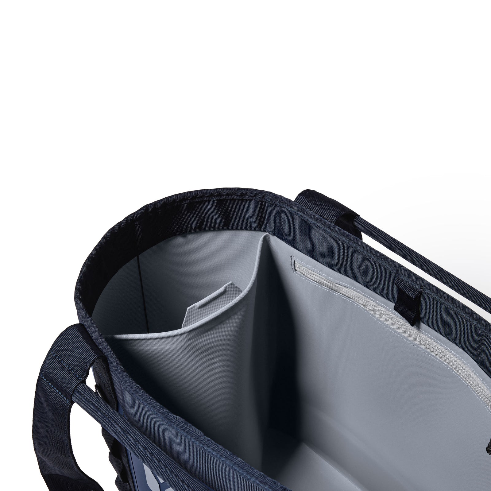 Ansicht der YETI® Tragetasche „Camino® Carryall 35“ in der Farbe „Classic Navy“ mit einem geräumigen, hellgrauen, isolierten Innenraum mit unterteilten Fächern und robusten, verstärkten Seitengriffen.