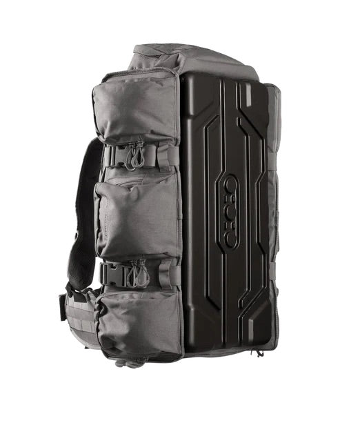 Grauer EBERLESTOCK UpRanger™-Rucksack mit drei Fronttaschen mit Reißverschluss und einer schwarzen, festen Schutzverstärkung an einer Seite, aufrecht vor weißem Hintergrund abgebildet – ein perfekter Rucksack für den Schießstand, um Ihre Wettkampfausrüstung sicher zu transportieren.