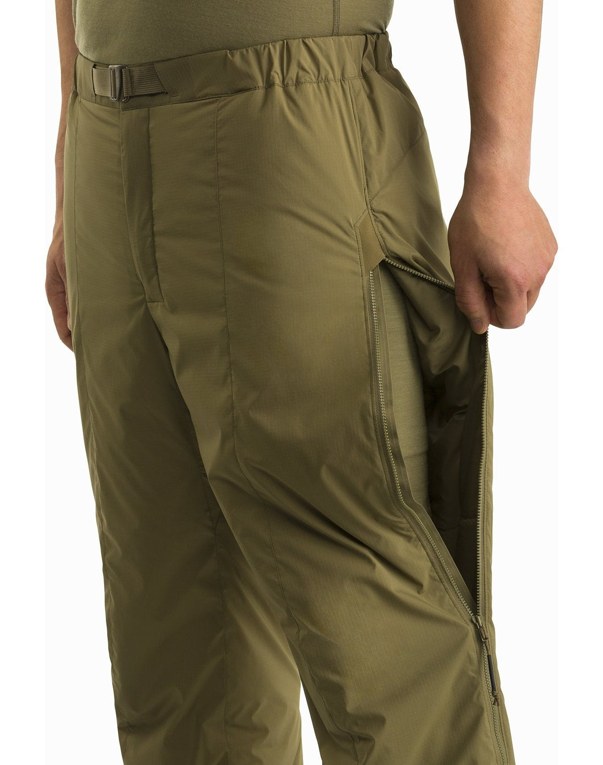 Eine Person, die die Arc'teryx Atom Pant LT Gen2-Crocodile von ARC'TERYX LEAF trägt, öffnet einen langen Seitenreißverschluss, um eine innere Schicht freizulegen. Nur der untere Teil des Oberkörpers und eine Hand sind sichtbar.
