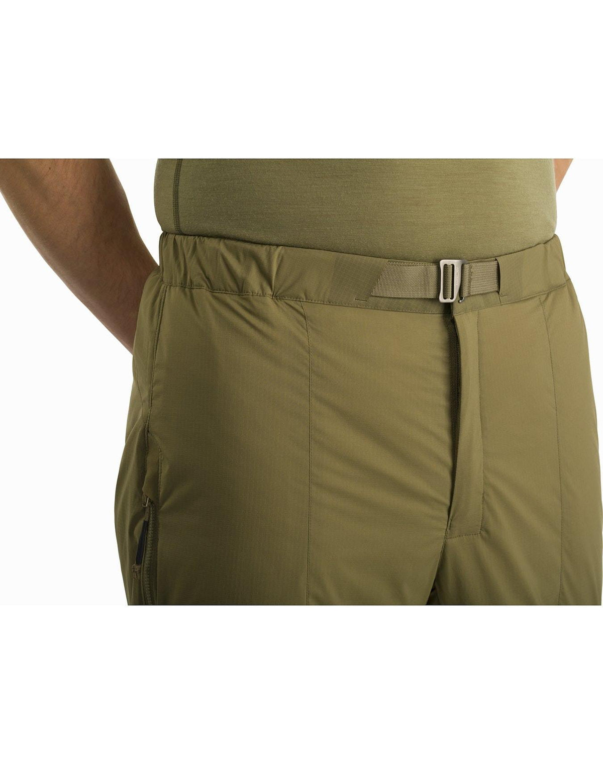 Eine Person trägt die ARC'TERYX LEAF Arc'teryx Atom Pant LT Gen2 in schwarz mit einem passenden Hemd. Die Hose hat einen integrierten verstellbaren Gürtel und eine Seitentasche mit Reißverschluss. Nur die Taille und die Oberschenkel sind sichtbar.