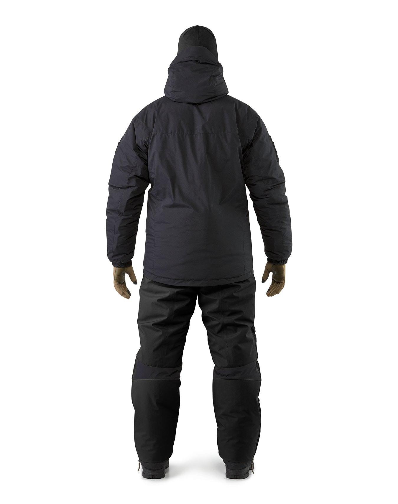 Eine Person, die eine schwarze ARC'TERYX LEAF Cold WX Jacket SV Gen1.4, eine isolierte Hose, Handschuhe und Stiefel trägt, steht mit leicht zur Seite gestreckten Armen vor einem einfarbig weißen Hintergrund.