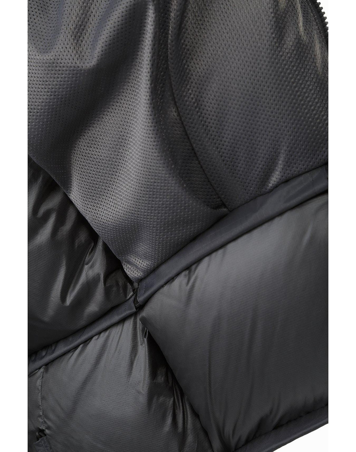 Nahaufnahme des ARC'TERYX LEAF Arc'teryx Cold WX Parka SVX - Wolf. Hervorzuheben ist das strukturierte, perforierte Gewebe im oberen Bereich und das glatte, glänzende Gewebe im unteren Bereich mit sichtbaren Nähten und Absteppungen.