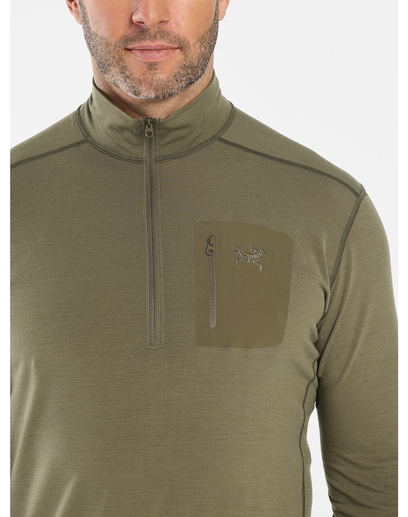 Ein Mann trägt einen schwarzen ARC'TERYX LEAF Cold WX Zip Neck AR mit einer Brusttasche mit Reißverschluss und gesticktem Logo. Das Bild zeigt seinen Oberkörper und einen Teil seines Gesichts.
