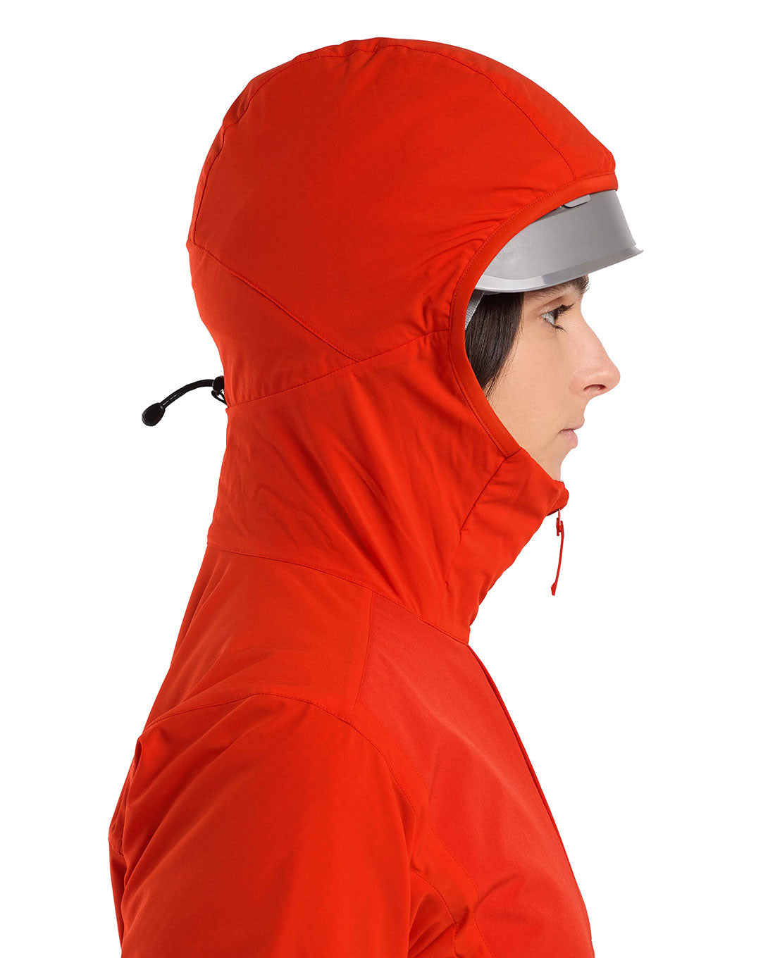 Eine Frau im Profil trägt einen leuchtend roten Arc'teryx Practitioner AR Hoody Women's - Dynasty von ARC'TERYX PRO, Kapuze über einem silbernen Helm, vor einem weißen Hintergrund. Diese atmungsaktive Isolationsjacke verbindet Stil mit Funktion.