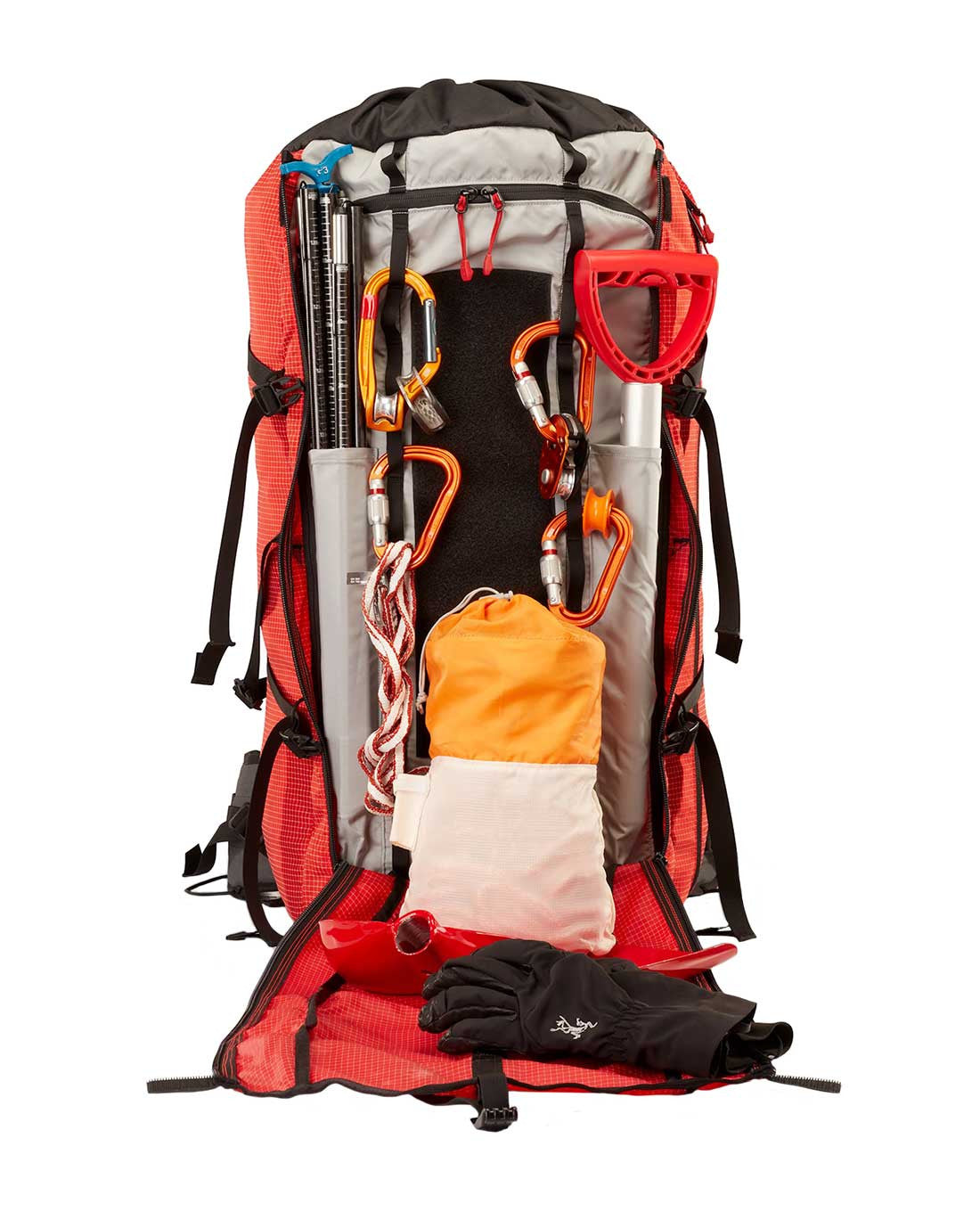 Das Arc'teryx Rescue Pack 50 von ARC'TERYX PRO öffnet den Reißverschluss und zeigt Karabiner, eine Klappschaufel, Trekkingstöcke, Seil, eine orange-weiße Tasche und schwarze Handschuhe - alles, was für Rettungsprofis wichtig ist.
