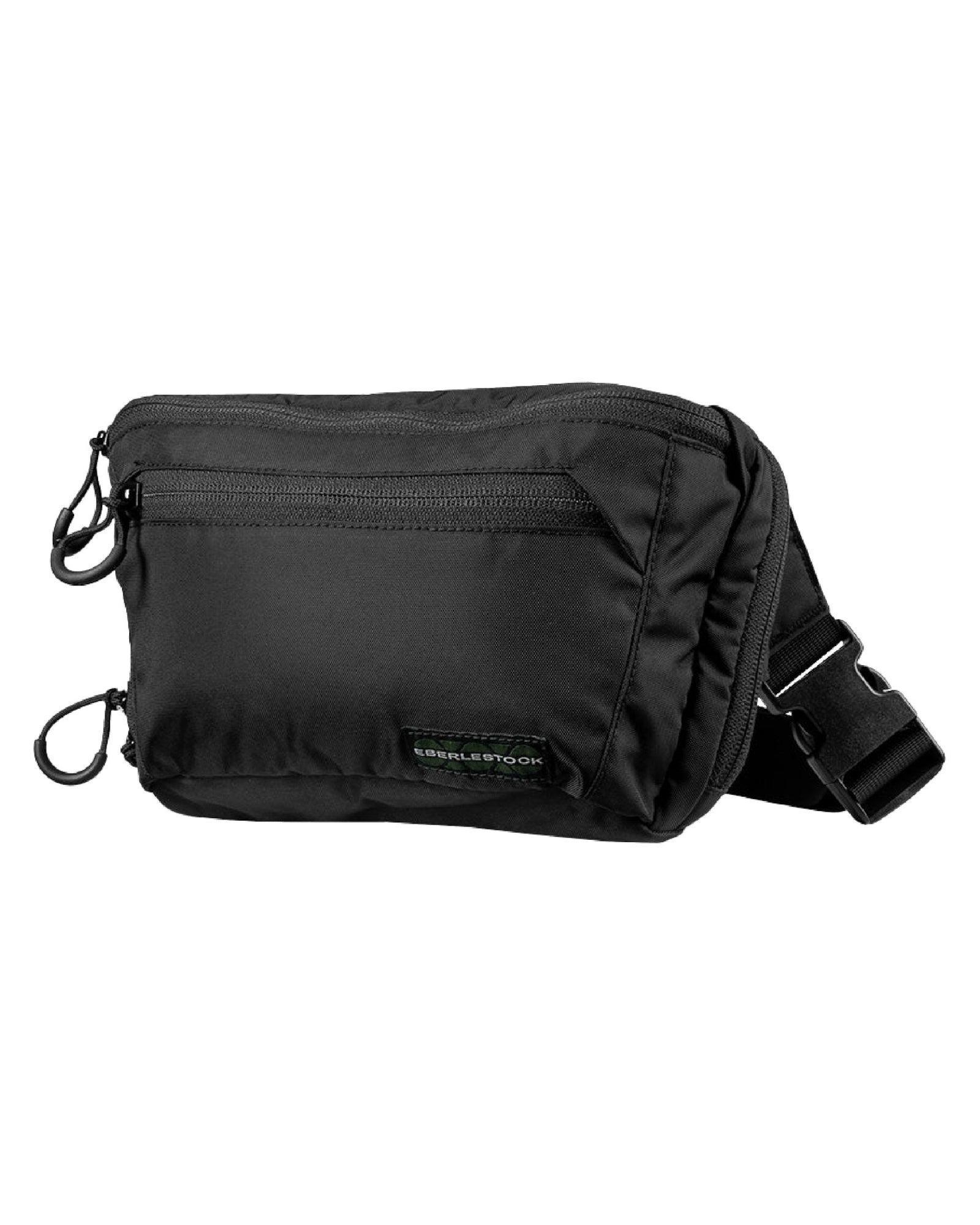 Die EBERLESTOCK Bando Bag XL ist eine schwarze taktische Umhängetasche mit mehreren Reißverschlussfächern und einem verstellbaren Gurt mit Kunststoffschnalle, ideal für das verdeckte Tragen, abgebildet auf weißem Hintergrund.