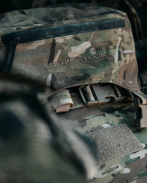 Nahaufnahme eines EBERLESTOCK Gunslinger II Rucksacks in Schwarz, mit sichtbarem Reißverschluss, gesticktem Logo und Schnallenriemen.