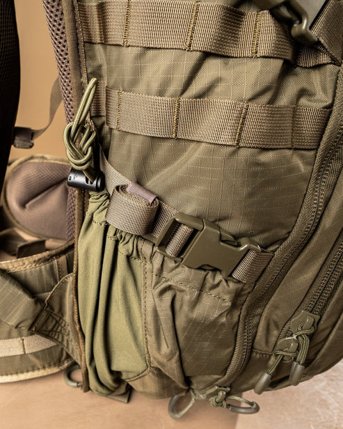 Nahaufnahme des EBERLESTOCK HiSpeed II taktischen Rucksacks in Coyote Brown, mit Seitentasche, Riemen, MOLLE-Gurtband, Schnalle und Reißverschluss - gefertigt aus 420D Ripstop Nylon für Strapazierfähigkeit und intelligente Aufbewahrung.