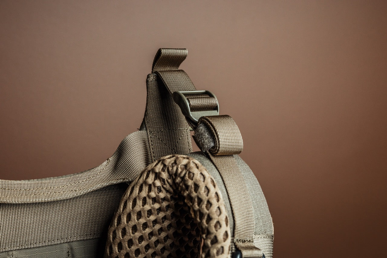 Nahaufnahme eines braunen taktischen Westengurts mit Mesh-Polsterung und Klettverschlussschlaufen, entwickelt für die Kompatibilität mit dem EBERLESTOCK Modframe - Military Green, vor einem einfarbig braunen Hintergrund.
