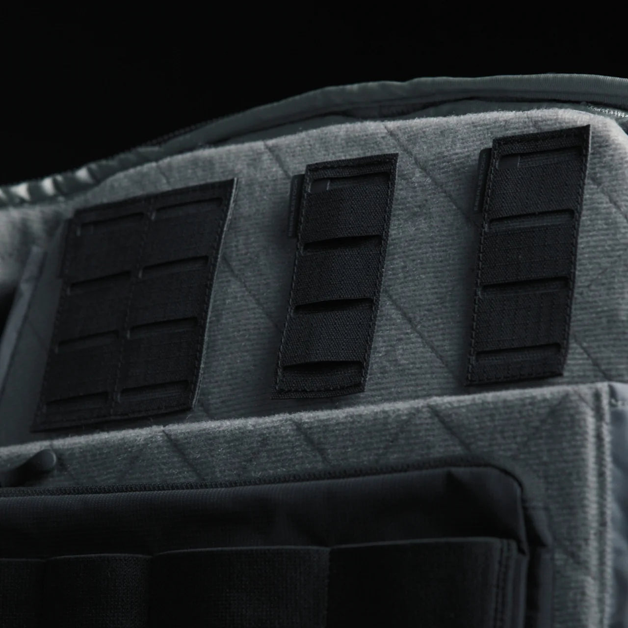 Nahaufnahme des EBERLESTOCK Molle-Adapters 3x1 (2er-Pack) aus robustem grauem 500D-Nylon mit schwarzen Klettverschlüssen im MOLLE-kompatiblen Design - ideal für taktische oder schützende Ausrüstung - vor einem dunklen Hintergrund.