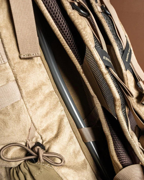 Nahaufnahme des EBERLESTOCK Eberlestock X2 - Mountain, eines robusten 40-Liter-Rucksacks mit gepolsterten Trägern, Netzfutter, schwarzem Trinkschlauch und sichtbaren Schnallen, Schlaufen und Nähten.