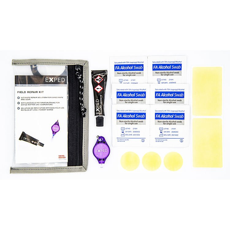 Das EXPED Exped Field Repair Kit enthält eine Reißverschlusstasche, Klebeflicken, Alkoholtupfer, zwei lila Schlüsselanhänger, eine Tube UV-Kleber, drei runde TPU-Flicken und drei rechteckige Flicken auf weißem Hintergrund.