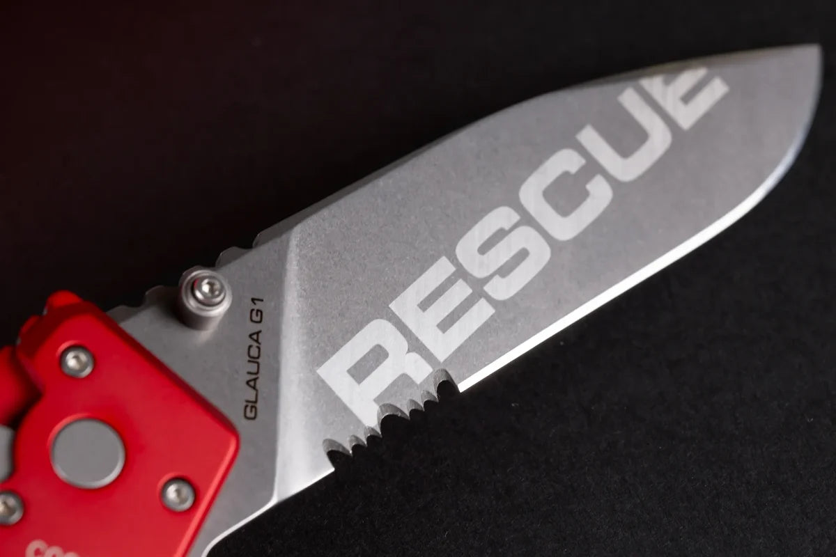 Eine Nahaufnahme eines EXTREMA RATIO Messer Glauca G1 Rescue Messers mit rotem Griff und silberner Klinge. Auf der Klinge ist fett "RESCUE" aufgedruckt, mit "GLAUCA G1" in kleinerer Schrift auf schwarzem Hintergrund.