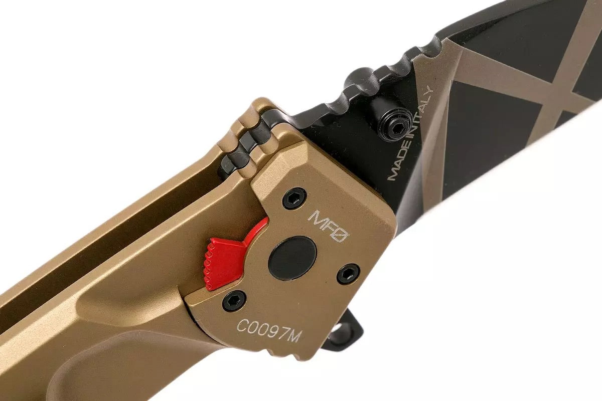 Nahaufnahme eines EXTREMA RATIO Extrema Ratio Messer MF0 T Desert Warfare mit hellbraunem Griff, schwarzer Klinge mit goldenen geometrischen Linien, rotem Sicherheitsschalter und den Markierungen MADE IN ITALY und MF0 auf Klinge und Griff.