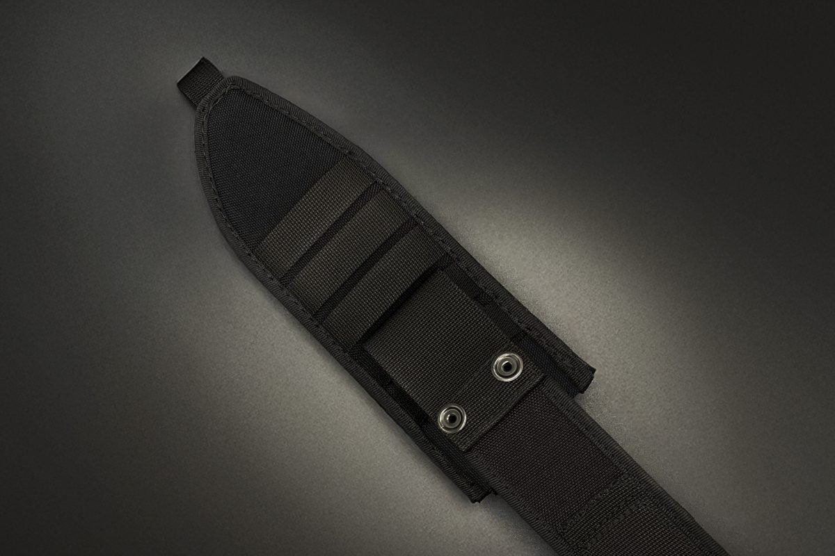 Schwarze Nylonscheide mit Gürtelschlaufe und Metalldruckknöpfen, gefertigt für das EXTREMA RATIO Messer Numen S600 Black, von EXTREMA RATIO, abgebildet auf dunkelgrauem Hintergrund bei gedämpfter Beleuchtung.