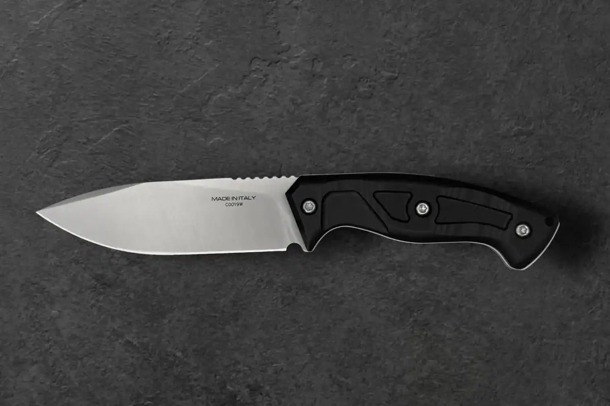 Das EXTREMA RATIO Extrema Ratio Messer Venatus F Black Satin verfügt über eine feststehende Klinge aus rostfreiem Böhler N690-Stahl mit der Aufschrift MADE IN ITALY und CO019M sowie einen schwarzen ergonomischen Griff, der auf einer dunkel strukturierten Oberfläche abgebildet ist.