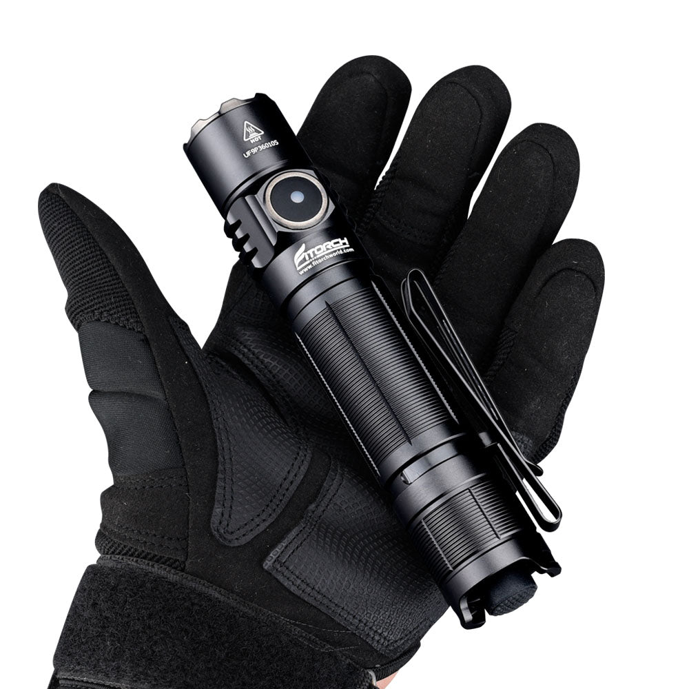 Eine Person, die einen schwarzen taktischen Handschuh trägt, hält die FITORCH Fitorch Taschenlampe P36 mit 3000 Lumen, seitlichem Knopf, Clip und USB-C-Anschluss vor einem schlichten weißen Hintergrund.