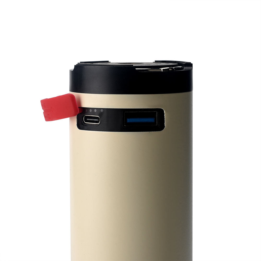 Eine Nahaufnahme der FITORCH Fitorch Teleskop-Campinglampe CP100 in Beige und Schwarz, mit USB- und USB-C-Anschlüssen, einer roten Gummiabdeckung und drei LED-Anzeigen - ideal als Campinglaterne oder Powerbank für Outdoor-Abenteuer.