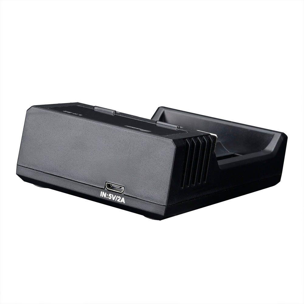 Eine schwarze FITORCH USB-Ladestation mit Dual-Slot für Li-Ion/Ni-MH, mit schrägem Schlitz, geriffelter Seite und sichtbarem Micro-USB-Anschluss (5V/2A) auf der Vorderseite, wird vor einem weißen Hintergrund gezeigt.