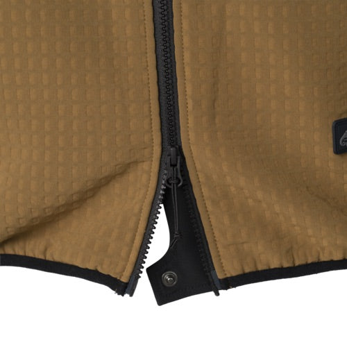 Nahaufnahme einer Taiga Green HELIKON-TEX Patriot PRO Fleece-Jacke mit schwarzem Reißverschluss, der unten teilweise geöffnet wird, um einen Druckknopf am Innenfutter freizulegen - ideal als windabweisendes Fleece für Outdoor-Abenteuer.