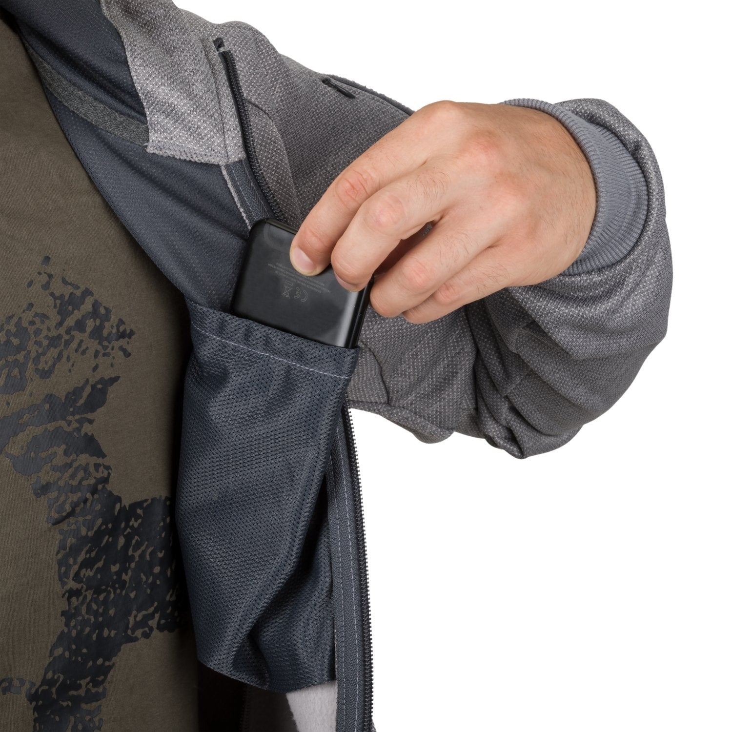 Eine Person steckt ein schwarzes Smartphone in eine innere Netztasche des HELIKON-TEX Urban Tactical Hoodie (FullZip)® in Melange Grey. Das Foto zeigt nur ihren Oberkörper und ihre Hand, wobei der Kapuzenpullover teilweise geöffnet ist.