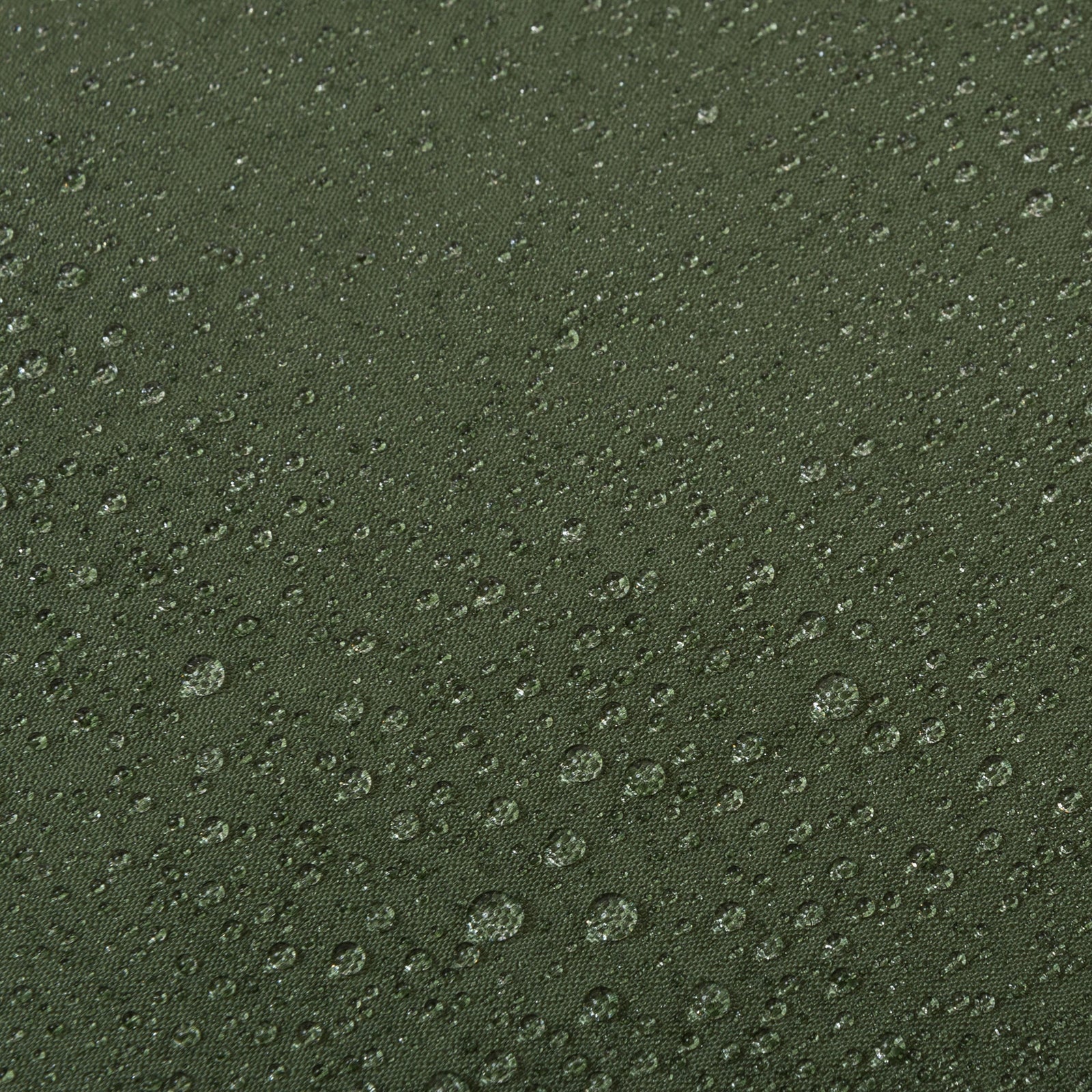 Nahaufnahme von Wassertropfen auf dem strukturierten, dunkelgrünen HIGHLANDER FORCES Highlander Biwaksack Hawk Bivy Bag Stoff, der seine beeindruckenden wasserdichten Eigenschaften deutlich zeigt.
