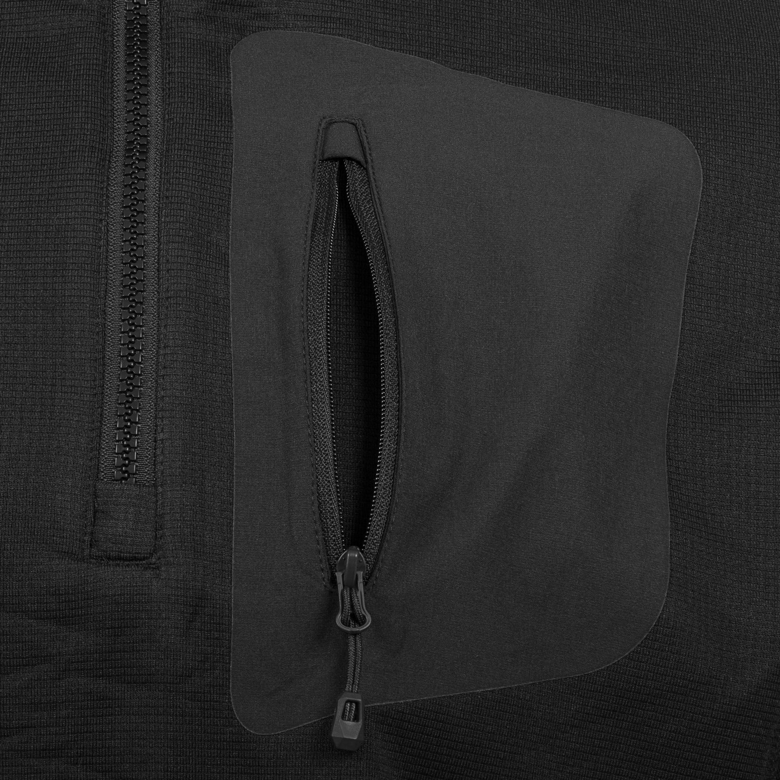 Nahaufnahme einer schwarzen Stofftasche mit vertikalem Reißverschluss auf dem Highlander Forces Tactical Hirta Fleece von HIGHLANDER FORCES, mit passenden schwarzen Reißverschlusszügen und sichtbaren Nähten auf dem Gitterfleece-Material.