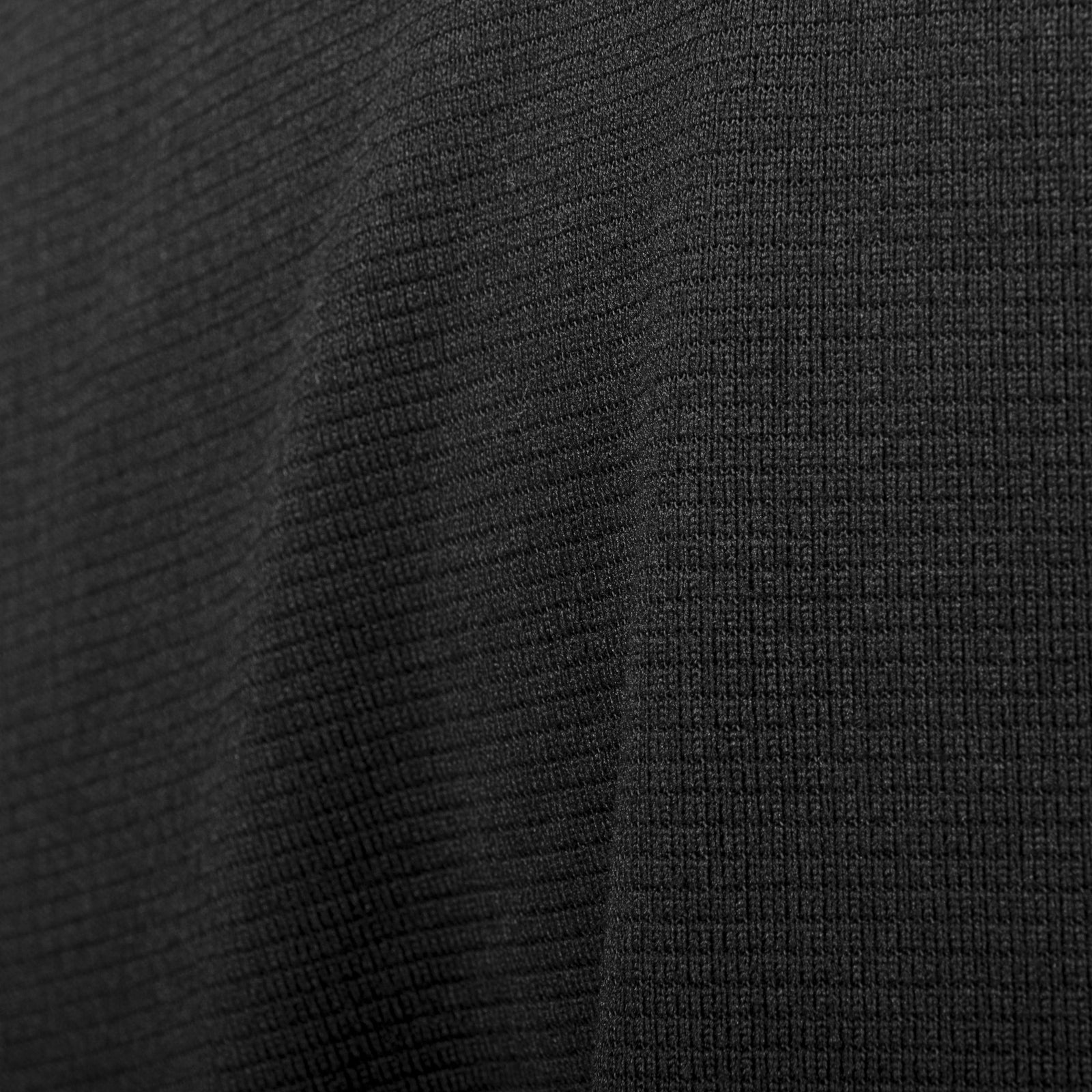 Nahaufnahme des HIGHLANDER FORCES Tactical Hirta Fleece - Black mit seiner feinen vertikalen Struktur und den weichen Falten - ein erstklassiger gerippter Stoff, der sich perfekt für eine taktische Fleecejacke eignet.