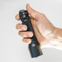 Eine Hand hält eine LEDLENSER Ledlenser Taschenlampe TT3R mit 1900 Lumen vor einem schlichten weißen Hintergrund.