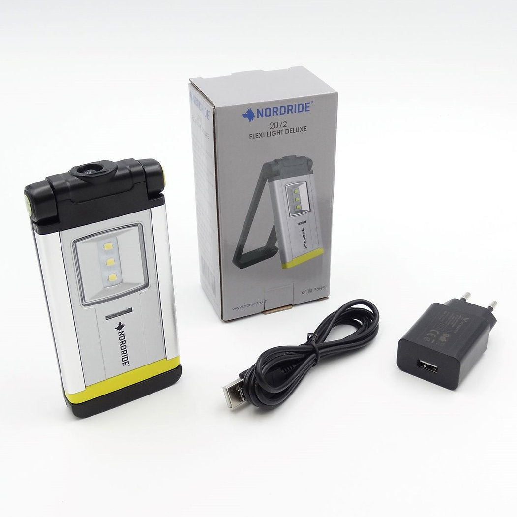 Die NORDRIDE Arbeitslampe Flexi Light Deluxe steht mit ihrer Box, dem USB-Ladekabel und dem Steckernetzteil auf einem weißen Hintergrund - eine ideale wiederaufladbare Arbeitslampe für jeden Arbeitsplatz.