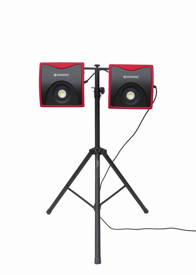 Ein schwarzes Stativ hält zwei NORDRIDE Nordride Arbeitsstrahler Power Light 60W, jeweils mit einem roten und schwarzen quadratischen Design, nebeneinander, mit einem Kabel von der rechten Leuchte vor einem weißen Hintergrund.