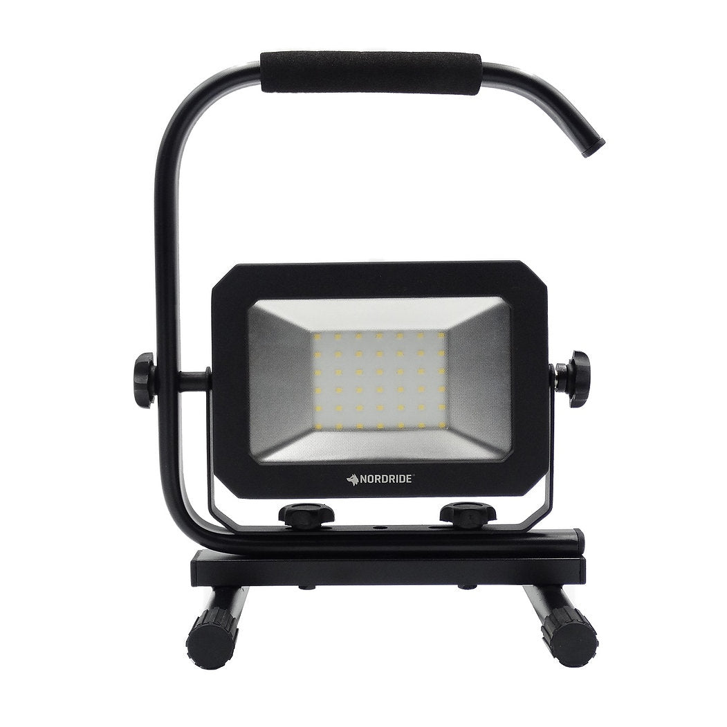 Der NORDRIDE Nordride Baustrahler Sector 30W IP65 ist eine tragbare LED-Arbeitsleuchte mit schwarzem, rechteckigem Rahmen, Griff, verstellbarem Ständer und LEDs mit Gittermuster. Schutzart IP65 für zuverlässige Leistung unter anspruchsvollen Bedingungen.