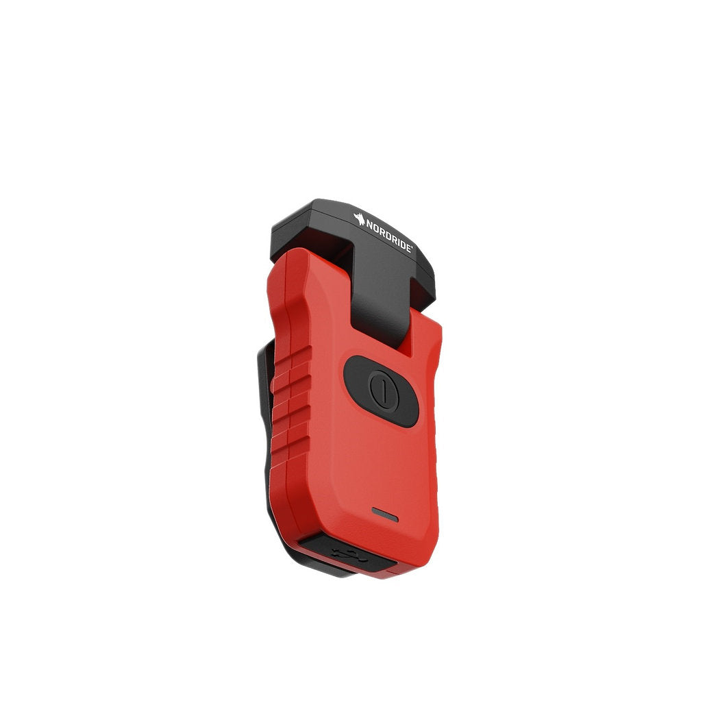 Die NORDRIDE Clipleuchte Scout Red ist eine wiederaufladbare rot-schwarze Lampe mit zentralem Einschaltknopf und oberem Clip, die sich ideal als Außenlampe eignet und auf weißem Hintergrund steht.
