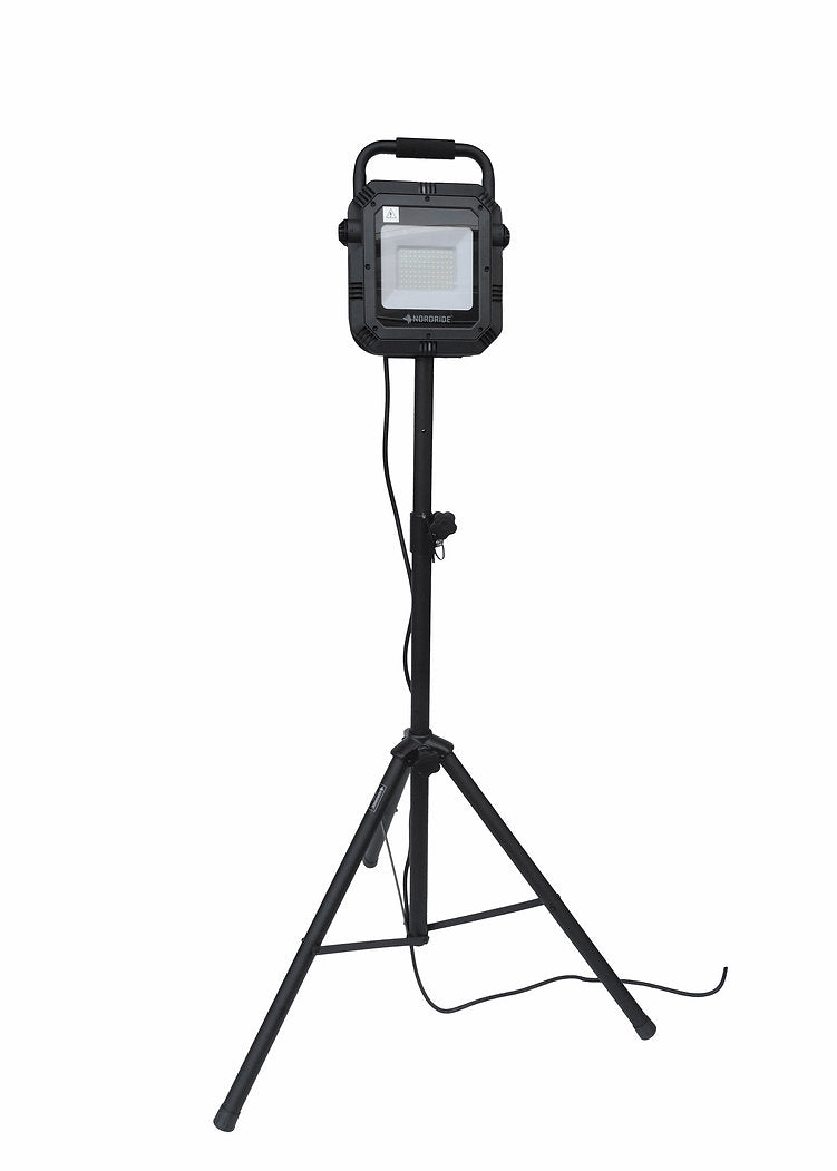 Die NORDRIDE Nordride Stativ ist eine schwarze, tragbare LED-Arbeitsleuchte, die auf einem verstellbaren Stativ montiert ist, wobei das Netzkabel seitlich herausragt, dargestellt vor einem weißen Hintergrund.