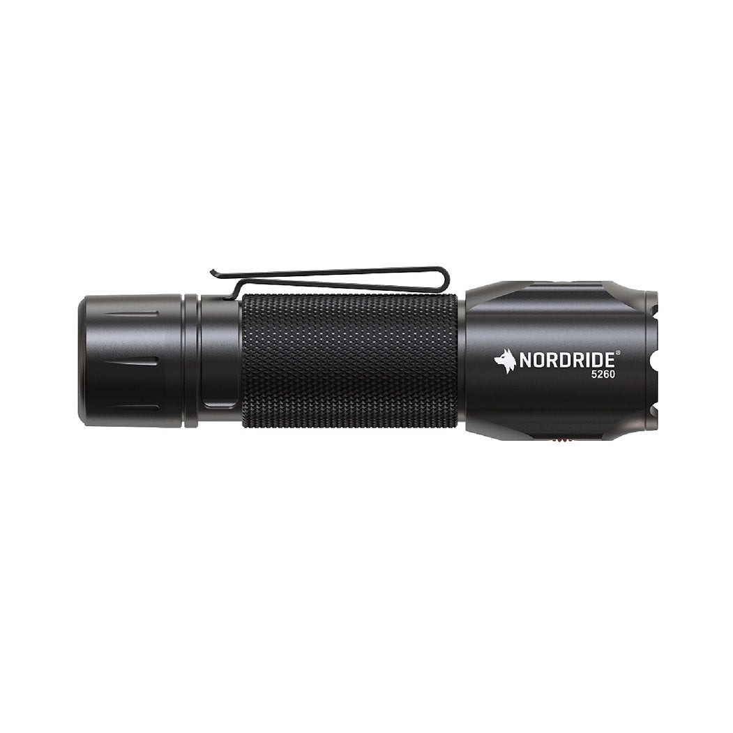 Eine schwarze NORDRIDE Nordride Taschenlampe Spot Defender R mit 1100 Lumen, strukturiertem Griff, seitlichem Clip und Markenaufdruck nahe dem Kopf ist auf weißem Hintergrund abgebildet.