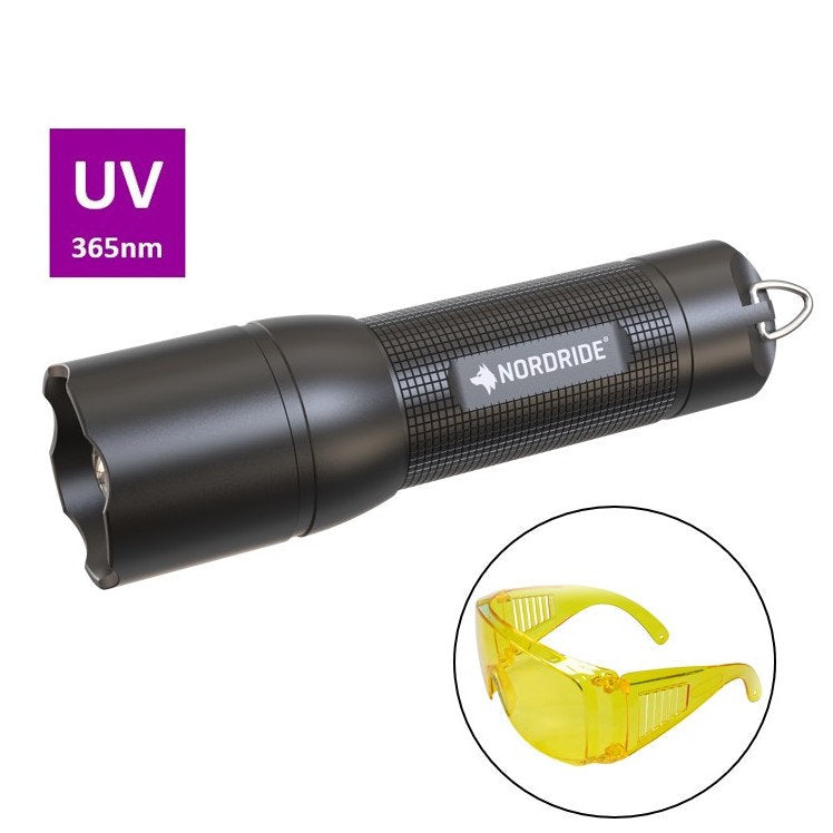 Eine schwarze NORDRIDE Nordride Taschenlampe Spot UV 365 A Set mit einem Metallschlüsselring ist über einer gelben Schutzbrille abgebildet. Ein lila Etikett sagt "Spot UV Lampe 365nm.