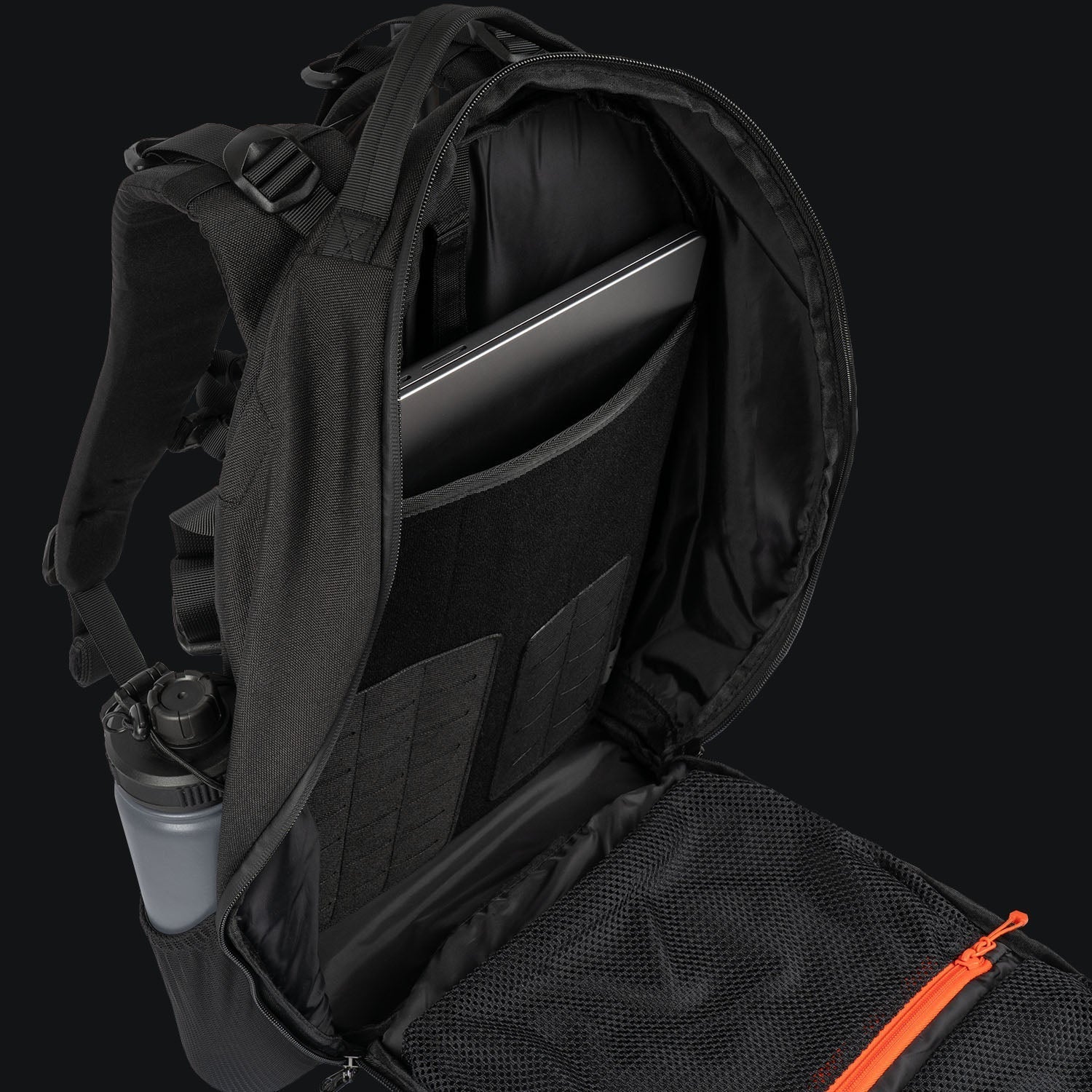 Der STOIRM 25L Tactical Pack GEN2 von STOIRM, aufgeklappt vor schwarzem Hintergrund gezeigt, zeigt einen Laptop in der Hülle, Netztasche mit orangem Reißverschluss und Wasserflasche an der Seite - ideal als taktischer Rucksack für Outdoor-Ausrüstung.