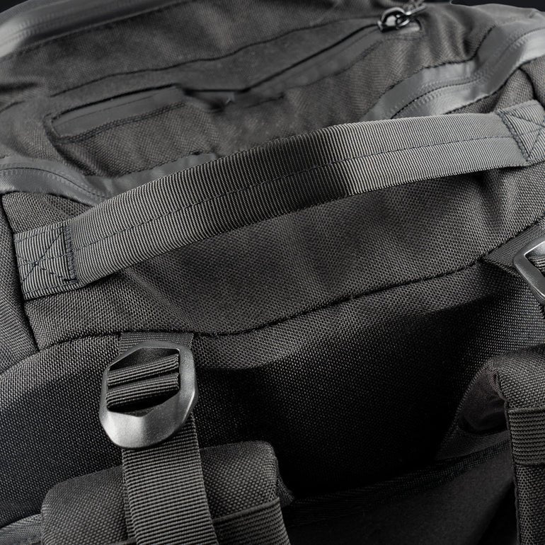 Nahaufnahme des STOIRM 40L Tactical Pack GEN2 in Schwarz mit robustem Stoffgriff, verstellbaren Riemen und Schnallen, die die hochwertige Beschaffenheit und robuste Konstruktion dieser taktischen Tasche von STOIRM unterstreichen.