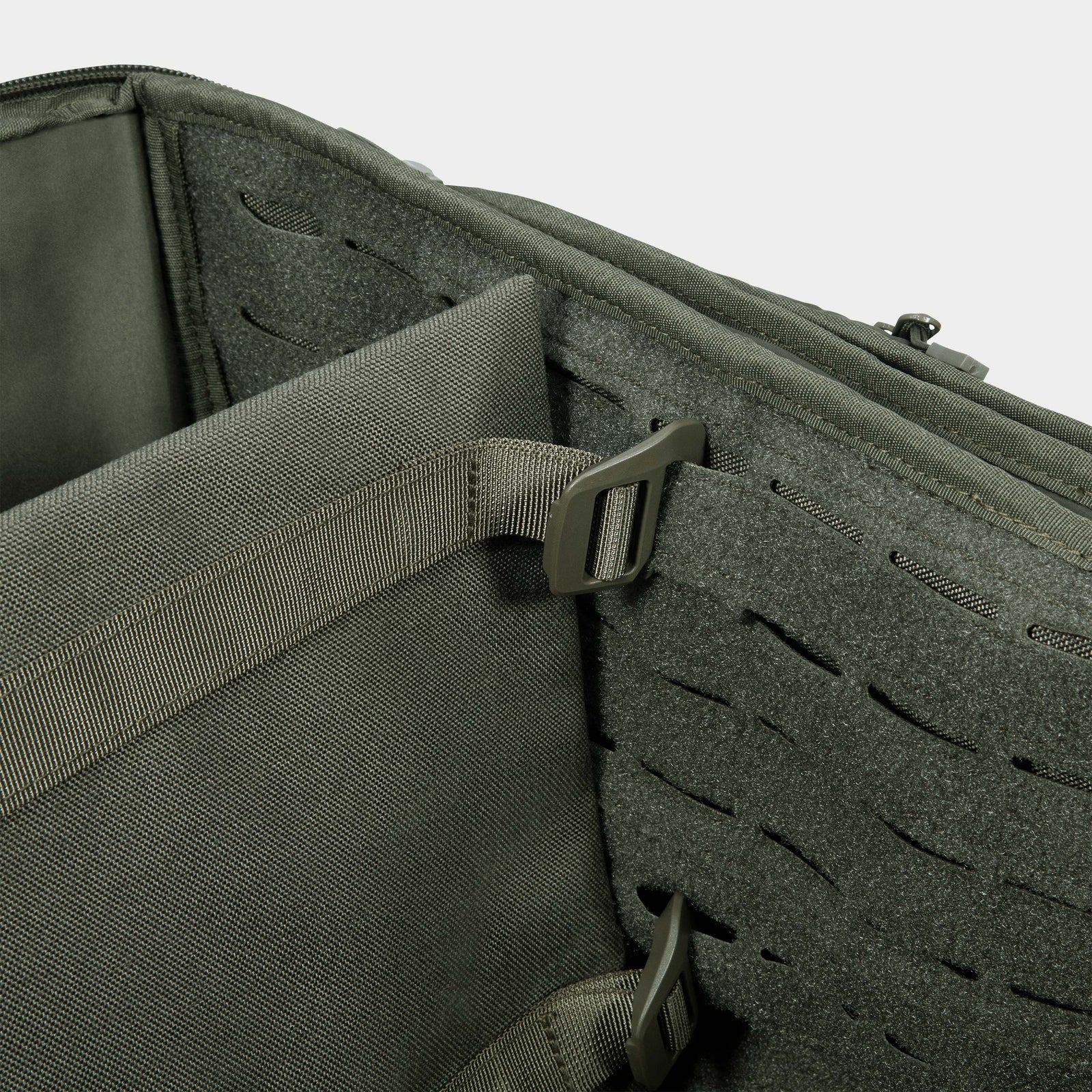 Nahaufnahme des Innenraums der STOIRM 50L Duffel Bag von STOIRM mit Gurtbändern, einer Trennwand und lasergeschnittenen MOLLE-Schlaufen an der Seite zur Befestigung von modularem Zubehör.
