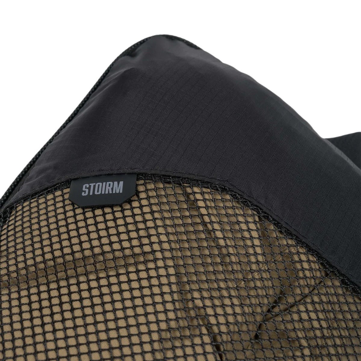 Der STOIRM Travel Cube mit Wäschesack ist ein schwarzes und hellbraunes Kissen, das für organisiertes Reisen entwickelt wurde und als kompakter Packwürfel von STOIRM dient.