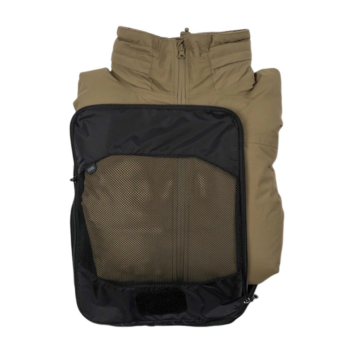 Eine hellbraune Jacke liegt ordentlich gefaltet im STOIRM Travel Cube with Laundry Bag von STOIRM, wobei der Kragen und der Reißverschluss der Jacke an der Oberseite des schwarzen Würfels sichtbar sind.