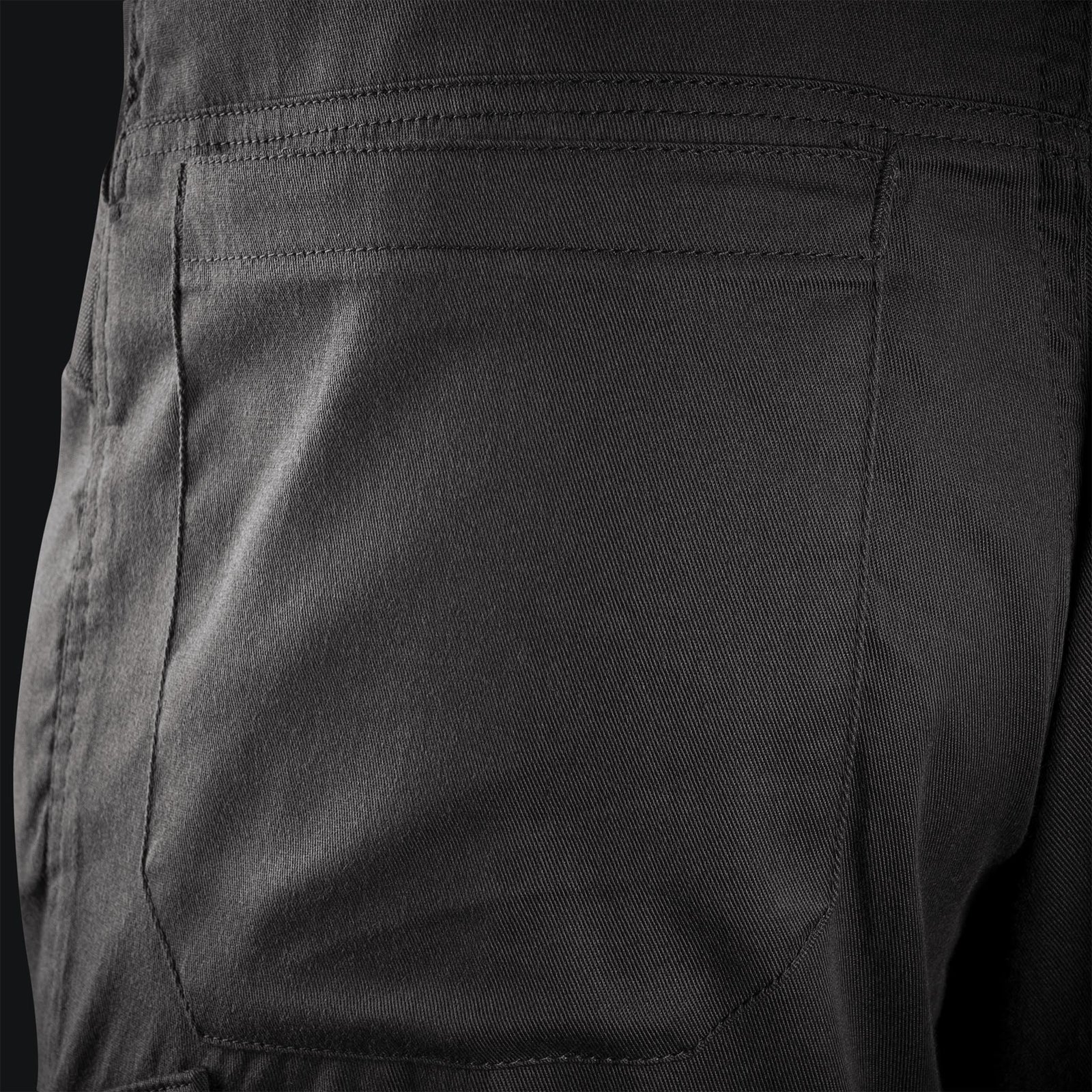 Nahaufnahme der Gesäßtasche der STOIRM Urban Trousers Gen2 in Ranger Green, die die komplizierten Nähte und die Textur des teflonbeschichteten Twill-Gewebes zeigt.
