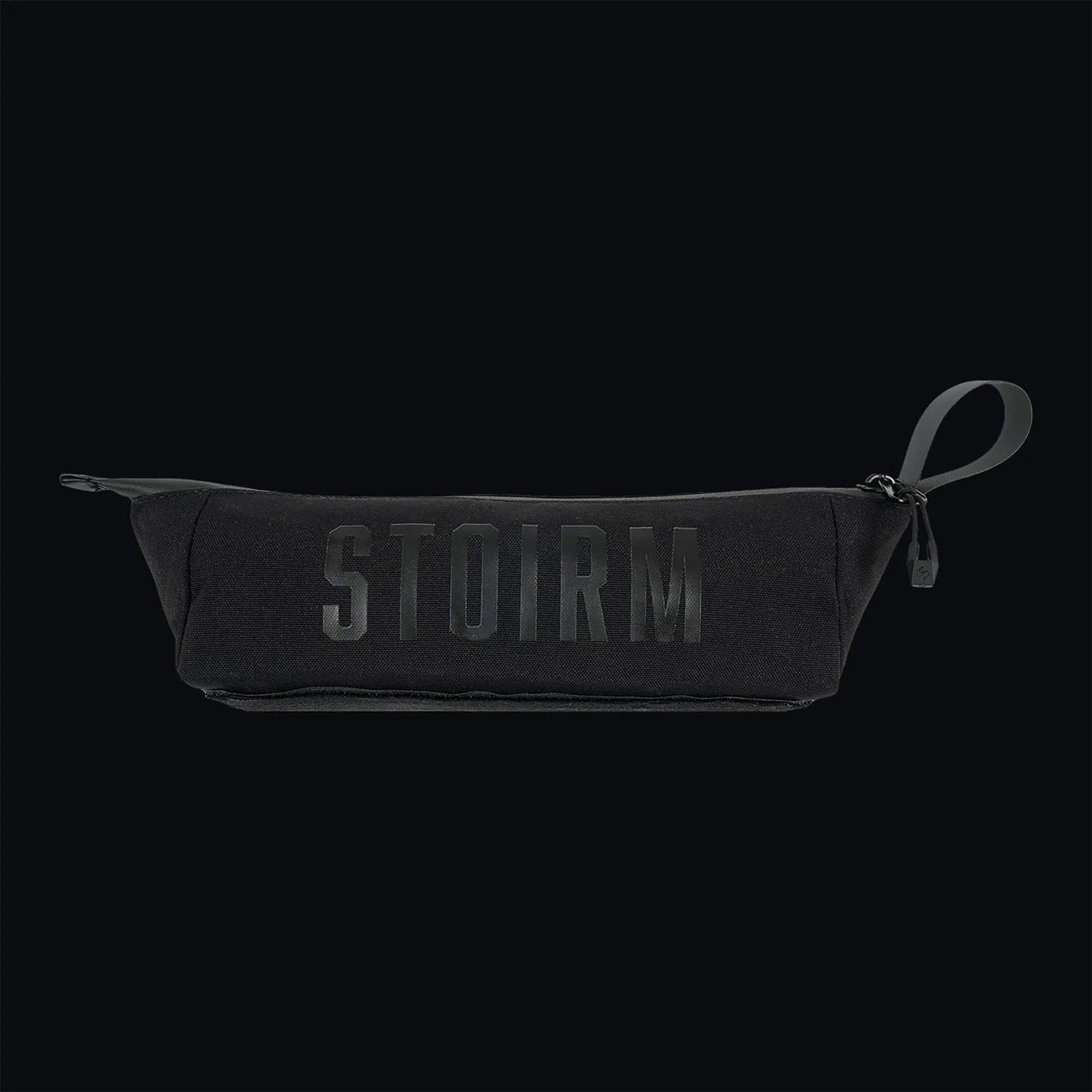 Die STOIRM Utility Pouch von STOIRM ist aus Segeltuch mit geprägtem Logo, Reißverschluss und Gummizuglasche gefertigt. Diese wasserdichte Tasche ist vor einem schwarzen Hintergrund abgebildet.