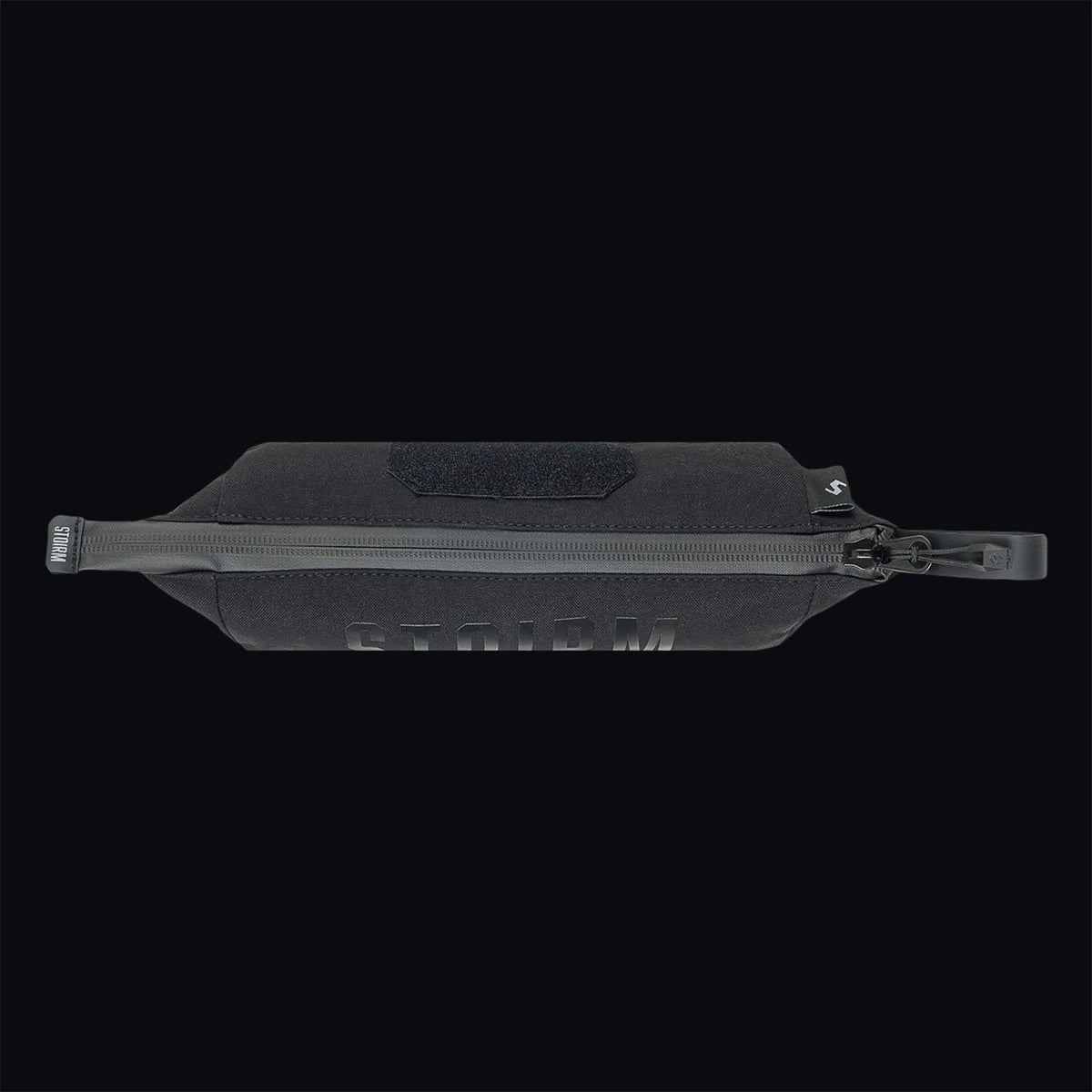 Die STOIRM Utility Pouch von STOIRM ist aus schwarzem 500D-Nylon gefertigt, verfügt über einen Griff und einen wasserdichten Reißverschluss, hat ein STORM-Logo auf der Vorderseite und ist auf einem schwarzen Hintergrund abgebildet.