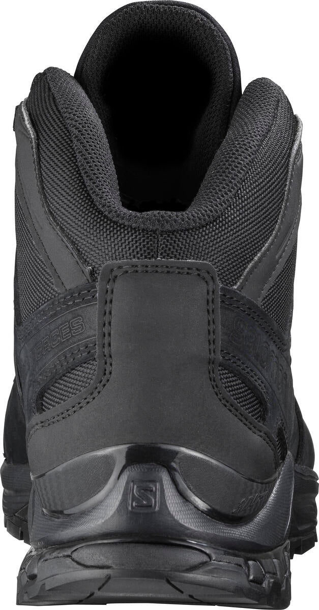 Rückansicht eines schwarzen Salomon XA FORCES MID WIDE DE Schuhs von SALOMON FORCES, mit strukturierter Knöchelpolsterung, Obermaterial aus Mesh, robuste Gummisohle mit Muster, sichtbares Markenlogo an der Ferse. Zertifiziert nach der Norm ISO 20347.