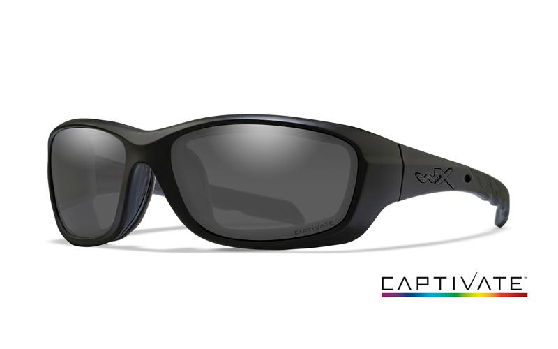 Mattschwarze Wiley X Schutzbrille GRAVITY Wraparound-Sonnenbrille mit dunklen Gläsern und kleinem WX-Logo am Bügel. "CAPTIVATE" mit regenbogenfarbener Unterstreichung ist unten rechts abgebildet. Marke: WILEY X.