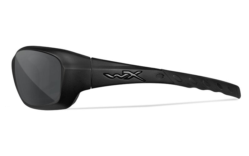 Die WILEY X Schutzbrille GRAVITY ist eine schwarze Wraparound-Sonnenbrille mit dicken Bügeln, erhöhtem WX-Logo an der Seite und strukturierten Bügelgriffen. Sie verfügt über dunkle rechteckige Gläser im klassischen Wiley X Schutzbrille-Stil.