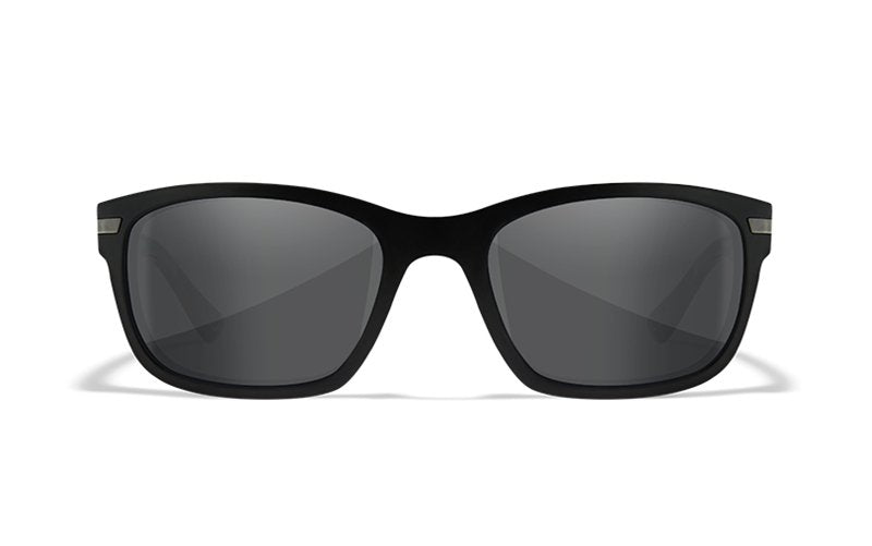 Eine schwarze rechteckige WILEY X Sonnenbrille HELIX Sonnenbrille mit dunkel getönten Gläsern und Seitenschutz, von vorne vor weißem Hintergrund.