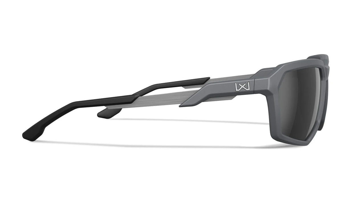 Seitenansicht der WILEY X Wiley X Sonnenbrille RECON in modernem Grau mit schwarzen Bügeln, geometrischem Rahmen und dunklen Gläsern. Ein kleines weißes Logo in der Nähe des Scharniers verleiht dieser Outdoor-Brille Stil und Funktion.